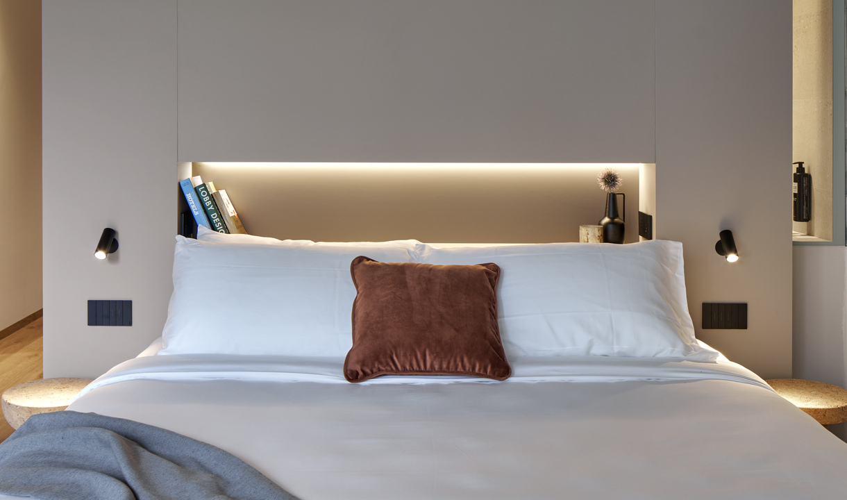 Image of a double bed illuminated on either side by two Vector Wall.