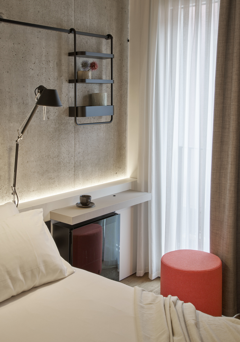 Image of a room with Tolomeo table illuminating the bed area.
